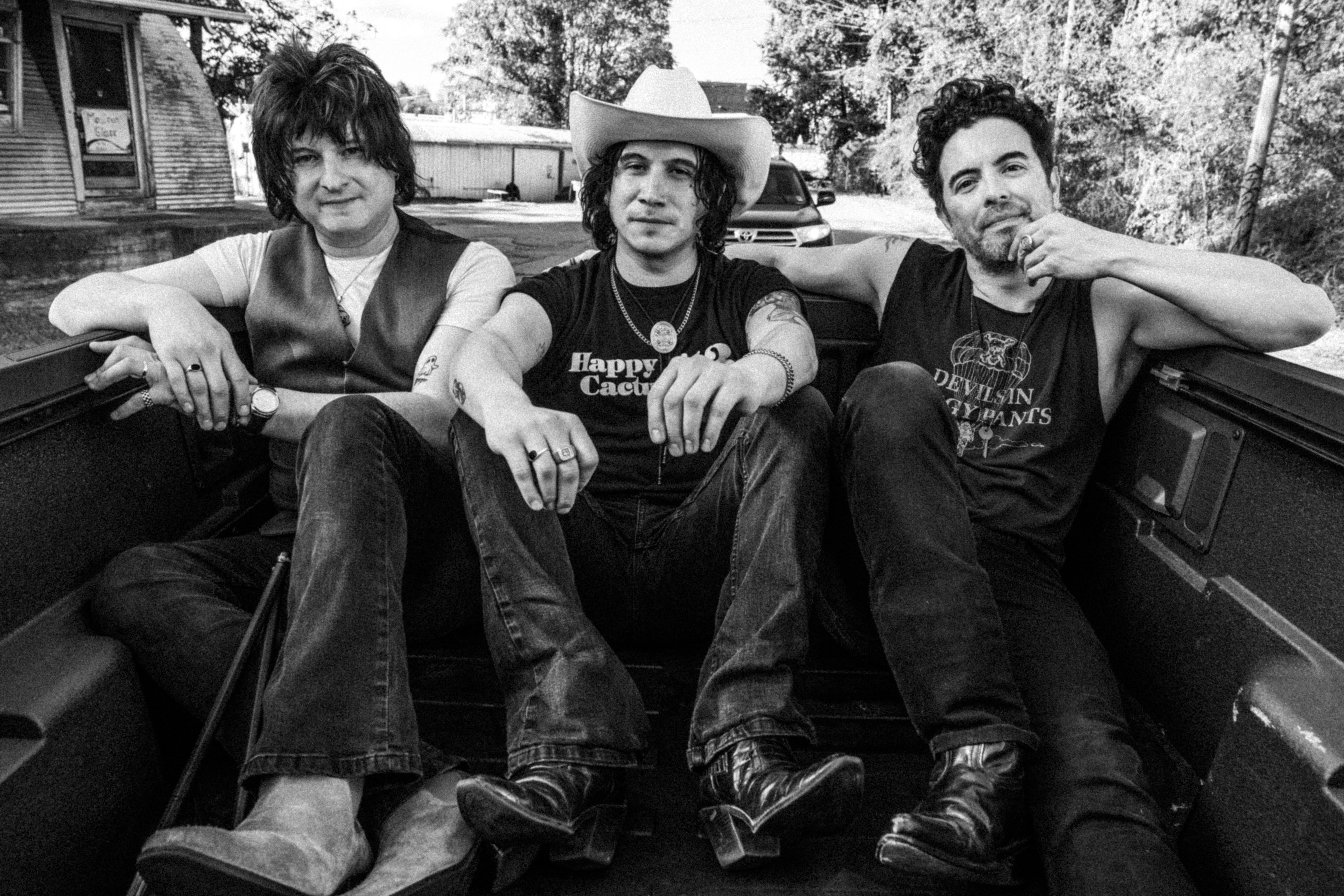 Band members sitting in a truck bed.
